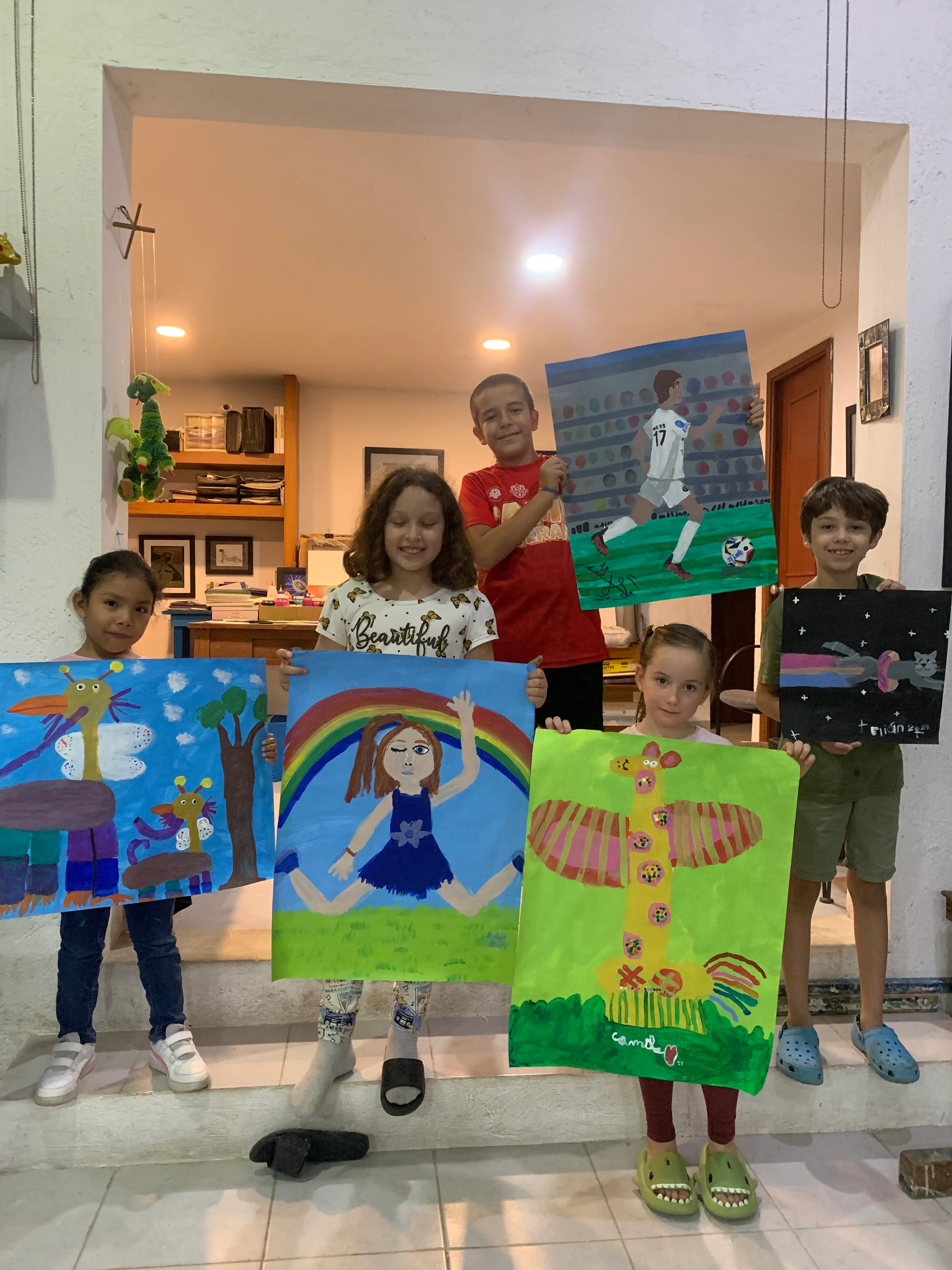 Niños mostrando orgullosos sus pinturas terminadas